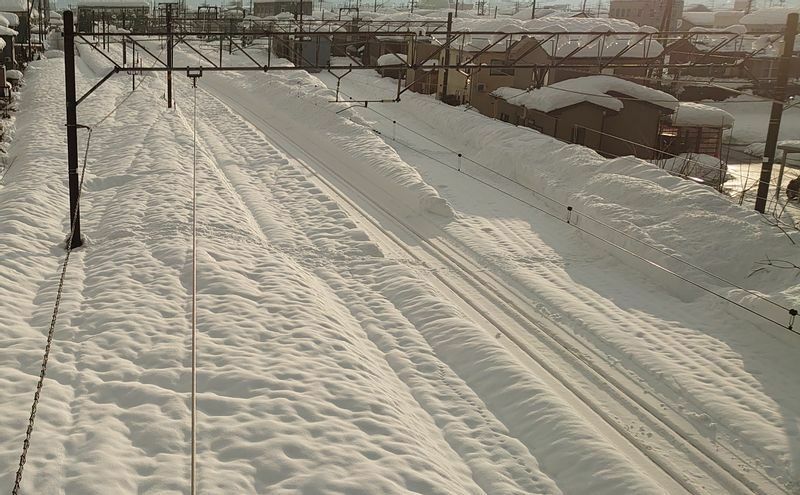 信越本線　来迎寺－越後岩塚間の線路の様子。直江津方面の線路はかろうじて顔を出しているが、それより左側の長岡方面の線路は完全に深雪の下に埋もれている（1月13日8:20、筆者撮影）