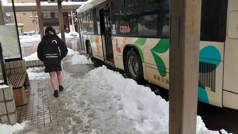 図2 バスターミナルのバスの降り口付近の除雪はいつも完璧。降り口付近を歩く長岡っ子の服装は街中でよくみかけるスタイル（筆者撮影）