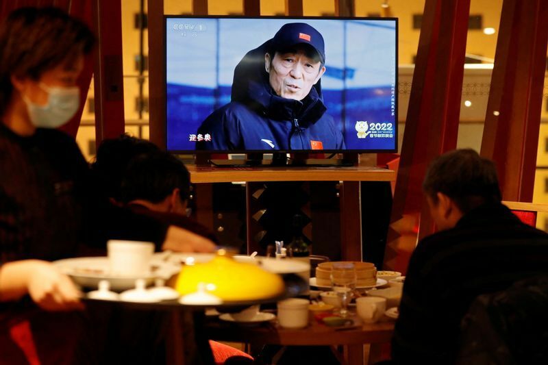 チャン・イーモウが北京オリンピックの開会式・閉会式の演出を手がける、という番組をレストランで見る人々。