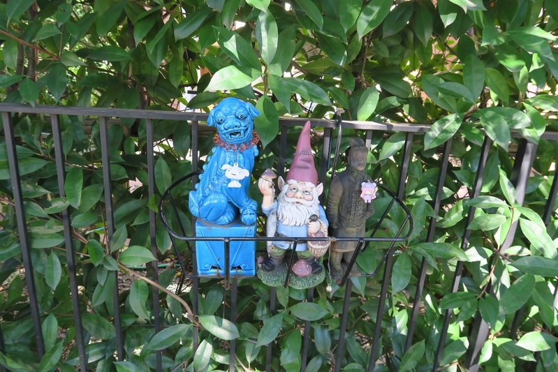 街路樹のある歩道の脇、民家の生け垣に小さな人形が飾られていた。筆者撮影