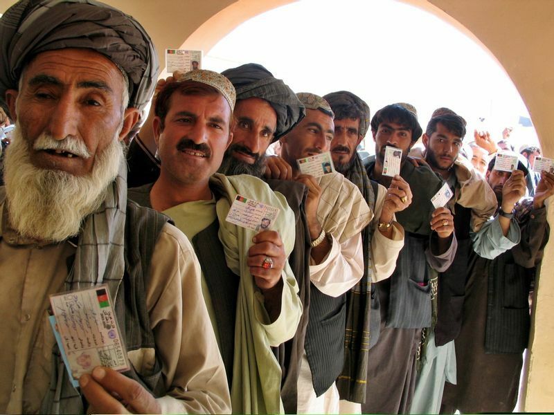 2005年9月18日パキスタン国境近くのスピン・ボルダックの議会選挙の投票所。選挙登録カードを見せるパシュトゥーン人有権者。タリバンは数十年ぶりの選挙を妨害できなかった。人々は脅迫に耐えながら投票した
