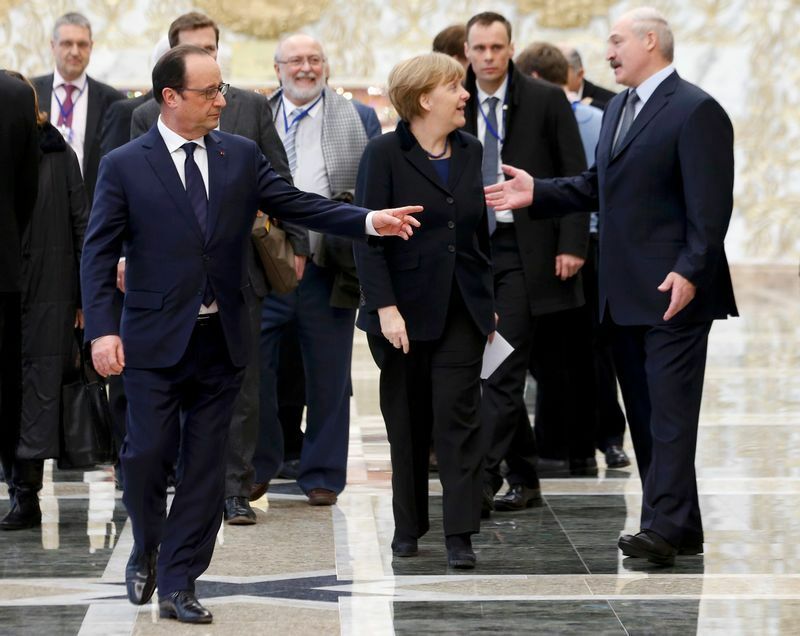 2015年2月12日ミンスクで行われたウクライナ危機の解決に向けた和平協議の後、ベラルーシのルカシェンコ大統領と話すメルケル首相とオランド大統領