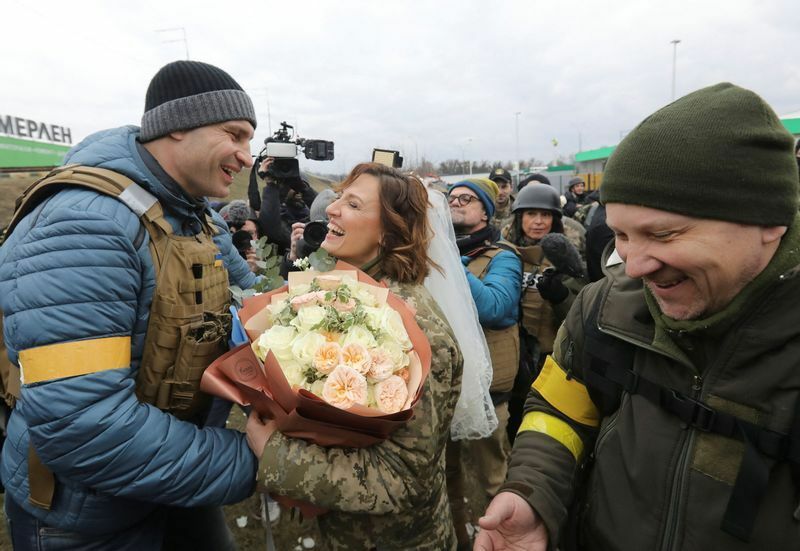 結婚したウクライナ領土防衛軍のレシア・イヴァシチェンコさんとヴァレリー・フィリモノフさんのメンバーを祝福するキエフのクリチコ市長。2022年3月6日、キエフの検問所にて
