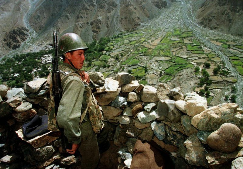 タジキスタンの山間部の国境で、カザフ人の国境警備員が自分のポストからアフガニスタン領土を眺めている。97年