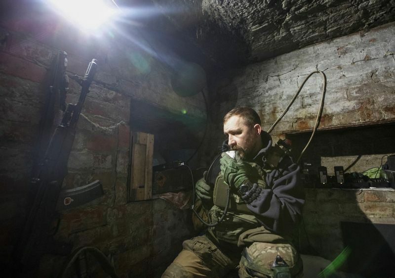 前線の陣地近くのシェルターでラジオ局を使う、ウクライナ軍の兵士。ドネツク州バフムート。2023年1月1日
