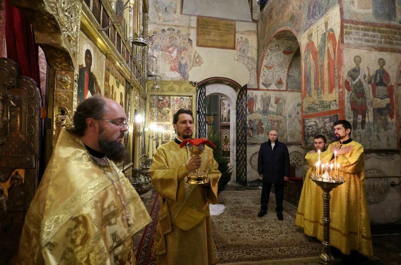 黄金のローブを身にまとった聖職者たち。たった一人で礼拝に参加するプーチン大統領