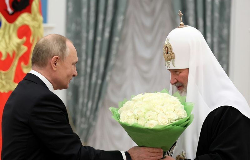 キリル総主教に聖アンドレイ使徒第一位勲章を授与する式典で、花を贈るプーチン大統領。2021年11月20日