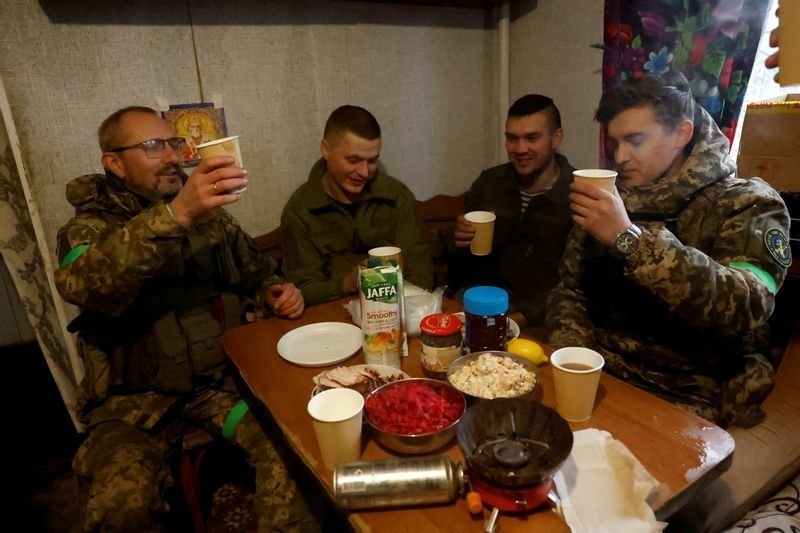 1月6日、クレミンナの最前線地域で、第80独立空襲旅団の兵士が、正教のクリスマスにロシアが発表した停戦中に、休憩所での夕食時にクリスマスに乾杯して祝う。