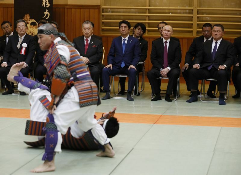 東京の講道館柔道場を訪れたオリンピック柔道金メダリストの山下泰裕氏、プーチン大統領、安倍首相（当時）、森元首相がデモンストレーションを見ている。2016年12月16日。