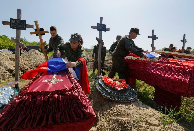 ロシア支配下のルハンシクの墓地で、死亡したロシア軍兵士60人と民間人3人の遺骨を埋葬する葬儀に参加する軍人ら。5月18日。