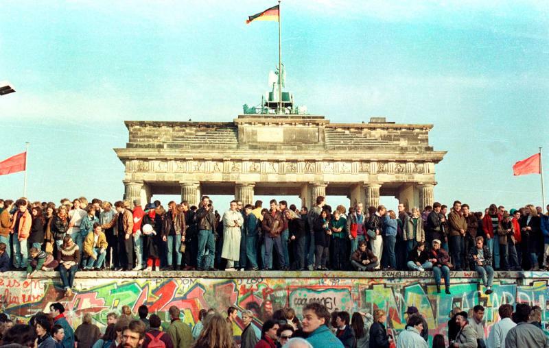 1989年11月10日、ベルリンのブランデンブルク門前のベルリンの壁の上で、また壁が閉じられてしまわないかと警戒を続ける西ベルリン市民