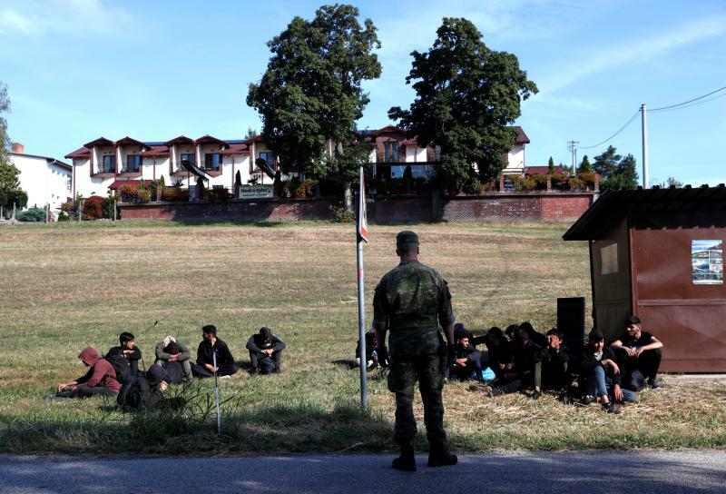 2023年9月15日、スロバキアのクラバ村(Chl'aba)で。ハンガリーの国境を越えた後に拘束された移民グループと、スロバキア軍兵士。ロイター/バーナデット シャボ