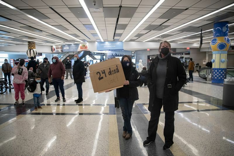 メキシコから戻ってくるクルーズを批判すべく空港で待ち受ける地元の人々