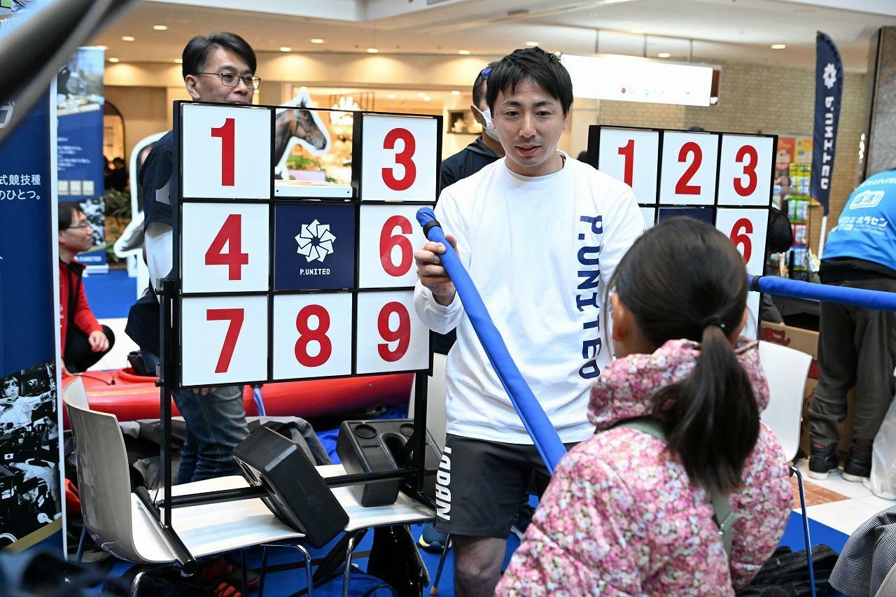 体験会に訪れた参加者と近い距離で競技を説明する車いすフェンシングの加納慎太郎（LINEヤフー）　写真・P.UNITED
