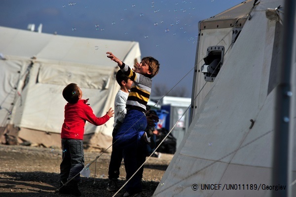 難民一時受け入れ所でシャボン玉で遊ぶ子どもたち。 (C) UNICEF