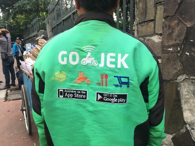 GO-JEKのジャンパー。提供しているサービス（配達、バイク、デリバリー、買い物）が書かれている