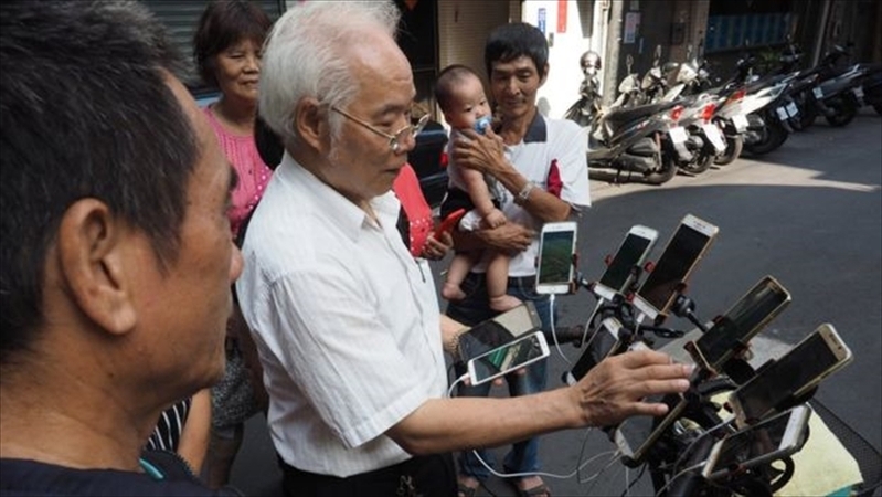 自転車にスマホを装着して「ポケモンGo」をしているChen San-yuan氏（EPA）