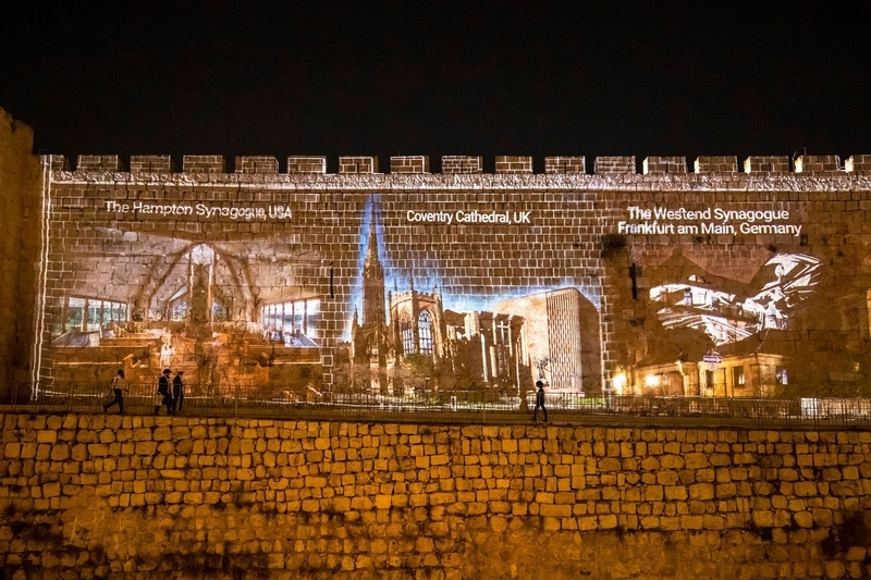 世界中から寄せられたメッセージが表示されるエルサレム旧市街の壁（International march of the Living提供）