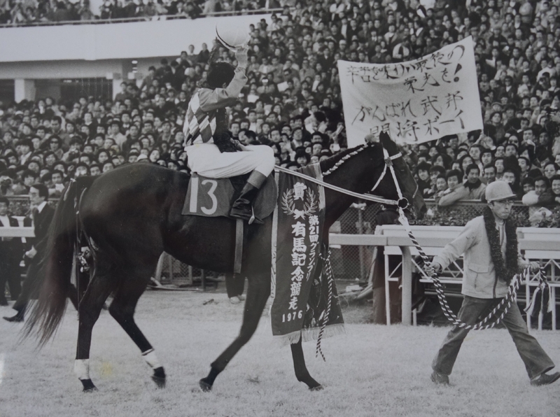 トウショウボーイが有馬記念を制した際の写真。鞍上は故・武邦彦騎手で曳いているのが長沼昭利厩務員の父・長沼昭二厩務員（当時）。（長沼氏提供）