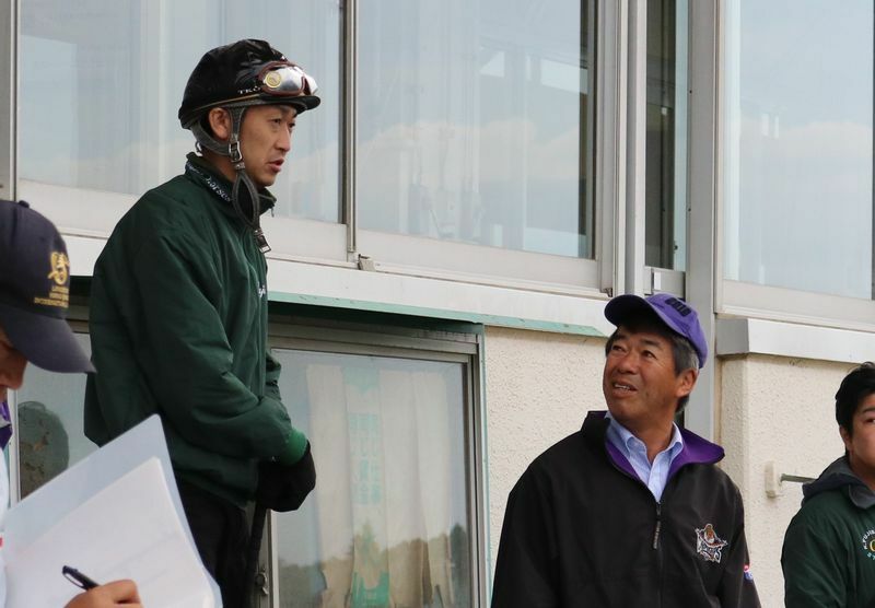 ベンチの上に乗り藤沢厩舎の調教に目を凝らす武幸四郎（左）に話しかける藤沢