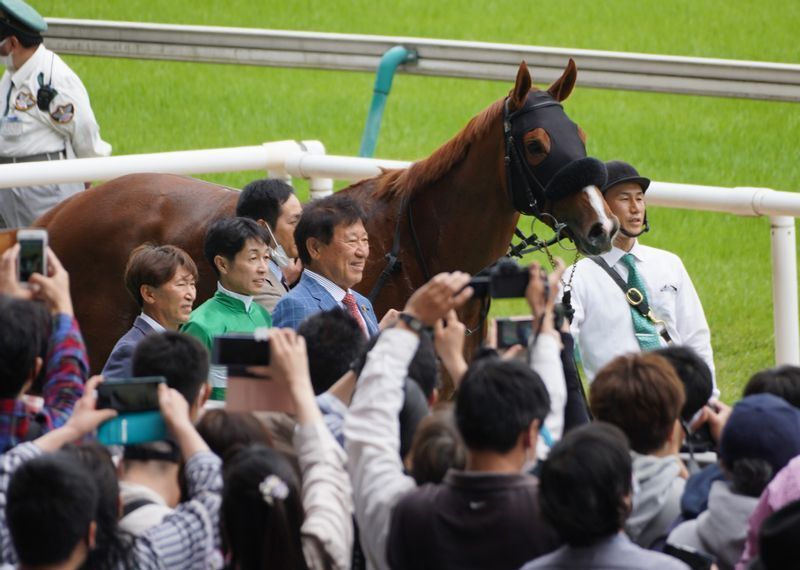 タッグを組んでの初勝利を祝う沢山のファンで囲まれたウィナーズサークル