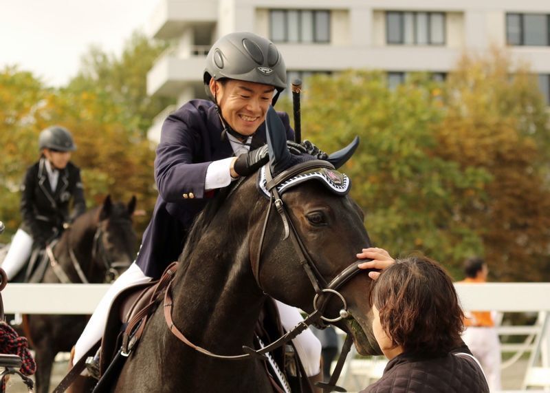 2人で協力して馬術の大会に出た事も（藤井勘一郎騎手提供写真、後頭部の写っている女性が沙織さん）