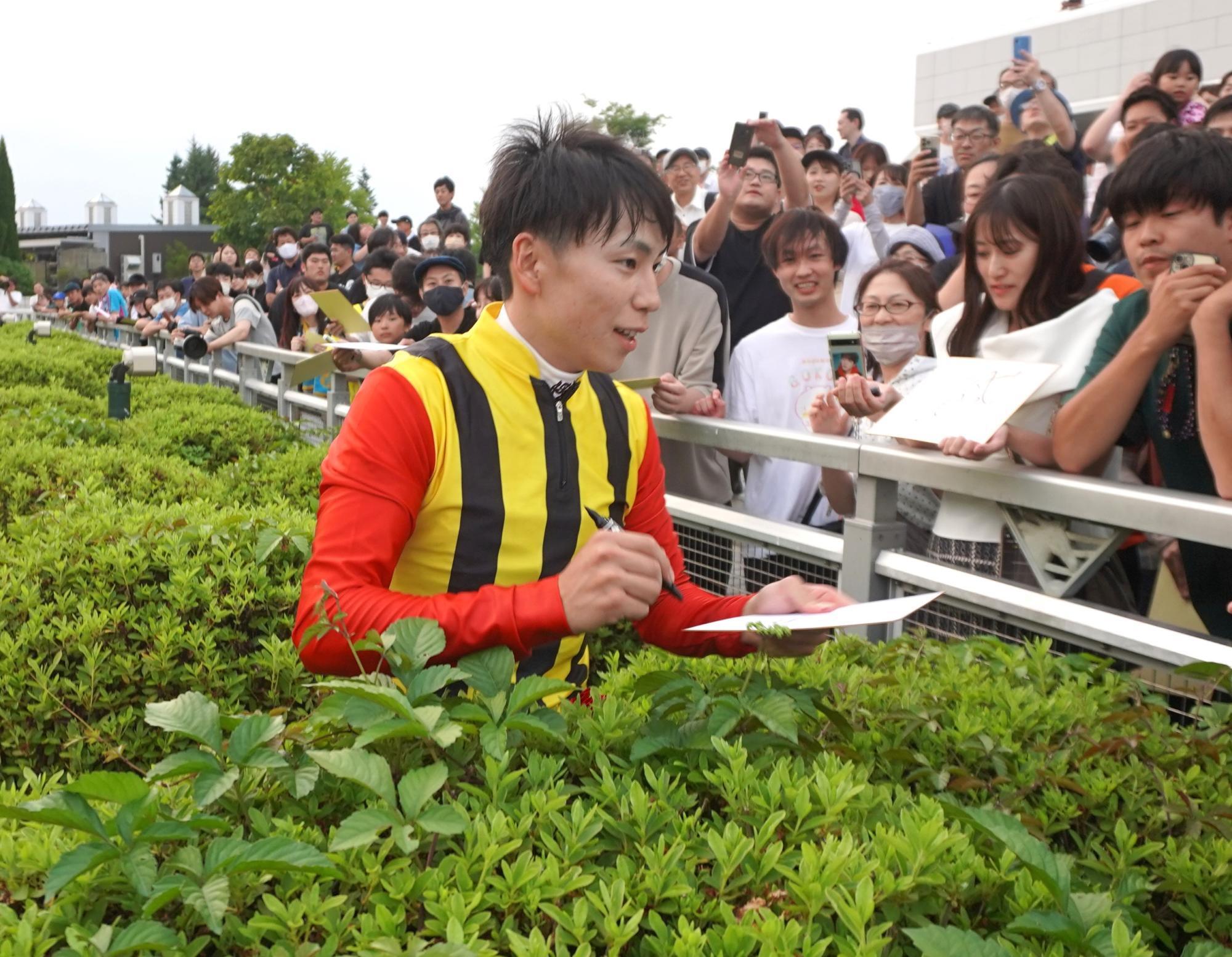 文字通り「垣根を越えて」ファンにサインをし続けた横山武史騎手