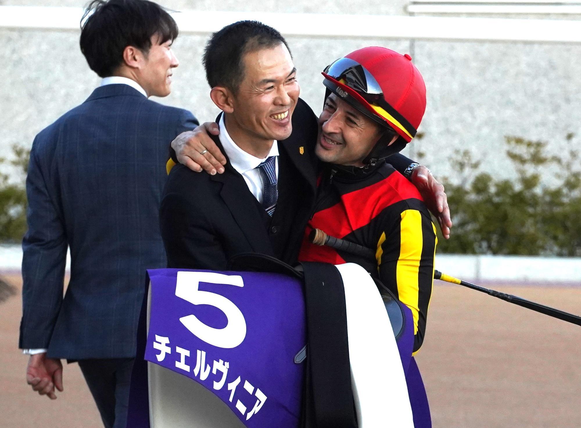 チェルヴィニアで牝馬２冠を達成しＣ・ルメール騎手と抱擁する木村哲也調教師