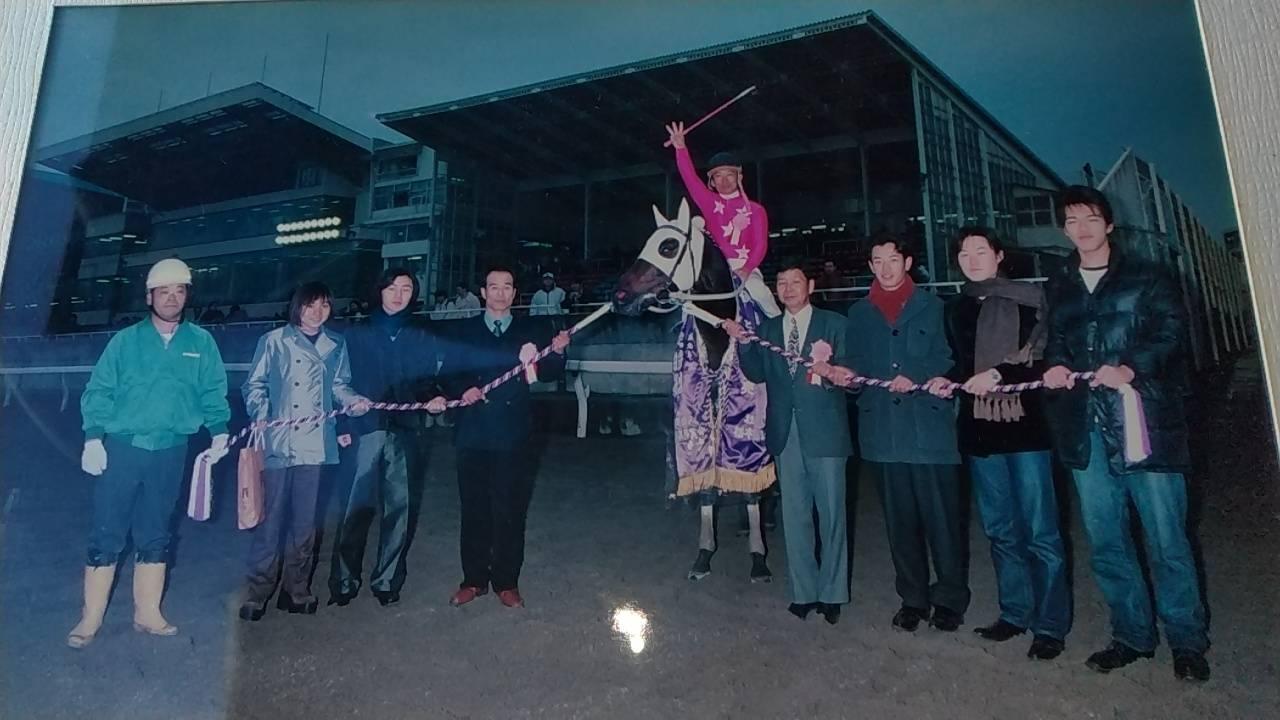 ブライアンズロマンの口取り写真。右から３番目が室井潔氏で、左から４人目が父の康雄調教師（当時、引退）（室井潔氏提供写真）