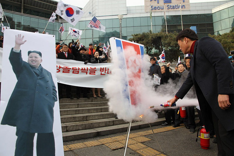 22日昼、北朝鮮の玄松月（ヒョン・ソンウォル）事前点検団長を迎え、反北朝鮮デモを行う保守政党「大韓愛国党」の市民たち。金正恩氏や北朝鮮の国旗をあしらった紙に火をつけるパフォーマンスを行った。筆者撮影