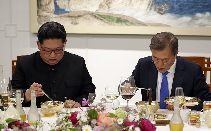 27日、首脳会談後の晩餐会で「平壌冷麺」をすする両首脳。「麺はややのびていた」という後日談が参加者から聞かれた。写真は板門店合同取材団。