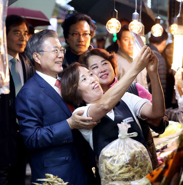 11月8日、慶尚北道の浦項（ポハン）市内にある市場を訪問した文大統領。市民とカメラに収まる。写真は青瓦台提供。
