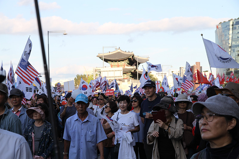 光化門広場から青瓦台（大統領府）に向けて行進する保守派デモに参加した市民たち。星条旗は米韓同盟を重視するという意思表示だ。3日、筆者撮影。