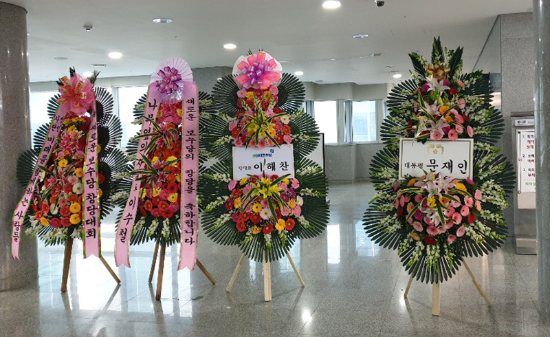 会場には文在寅大統領と、与党・共に民主党のイ・ヘチャン代表によるお祝いの花輪があった。自由韓国党からは無かった。5日、筆者撮影。