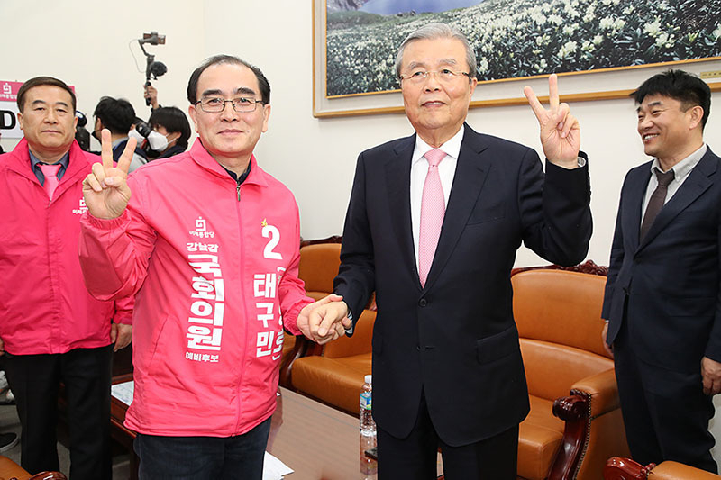30日、国会で握手する金鐘仁氏（右）と元駐英北朝鮮公使で未来統合党候補のテ・グミン（テ・ヨンホ）氏。金氏は以前、テ氏公認を「あり得ないこと」と強く批判していたが、仲直りとなった。同党HPより。