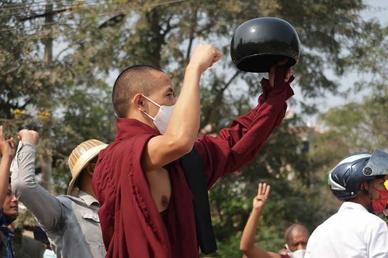 デモに参加する僧侶。お鉢をひっくり返しているのは「お前のお布施は受け取らない」という意味で、抵抗を表現している。金茂成さん撮影。