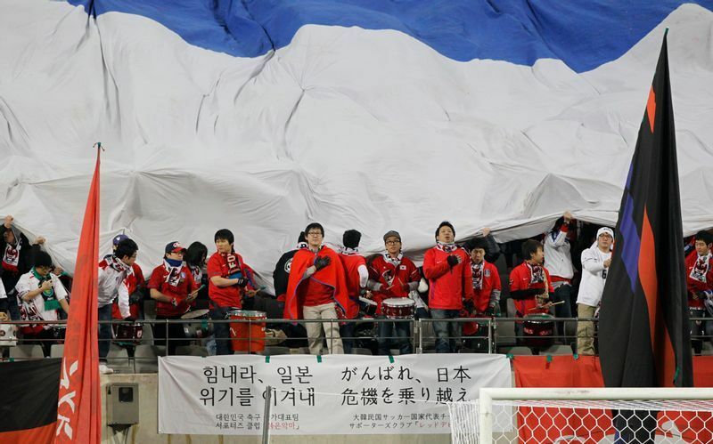 10年前の3月25日に行われたサッカー親善試合で「日本頑張れ」の横断幕を掲げる韓国のサポーターたち。