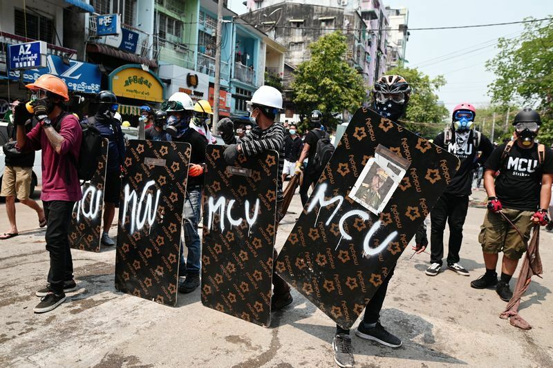 12日、ヤンゴン市内で軍部に反対するデモを行う市民たち。