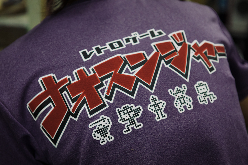 スタッフのみなさん。「レトロゲーム ナオスンジャー」とプリントされた制服を着用し、情熱をもって日々業務に取り組んでいる(吉田尚弘撮影)