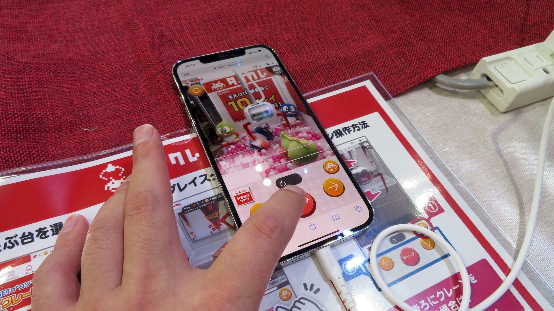 タイトーブースの「タイトーオンラインクレーン」体験コーナーに設置されたスマホ（※プレイヤーは筆者）