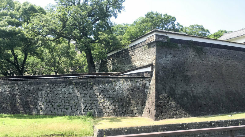 行きがけにバスから見た熊本城。石垣の上の塀が倒れている