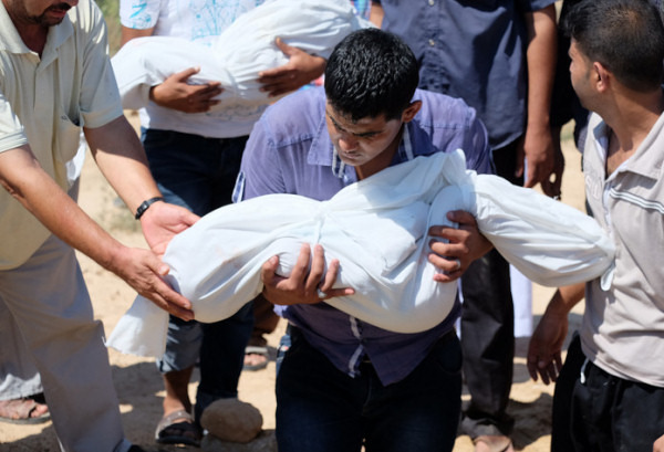 空爆の犠牲となった子ども達を埋葬する人々。ガザ中部で先月末撮影。