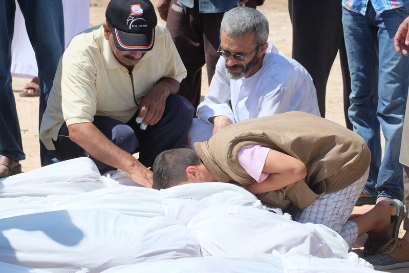 埋葬される遺体に別れを告げる親族ら。イスラエル軍による攻撃下のガザで。2014年7月撮影