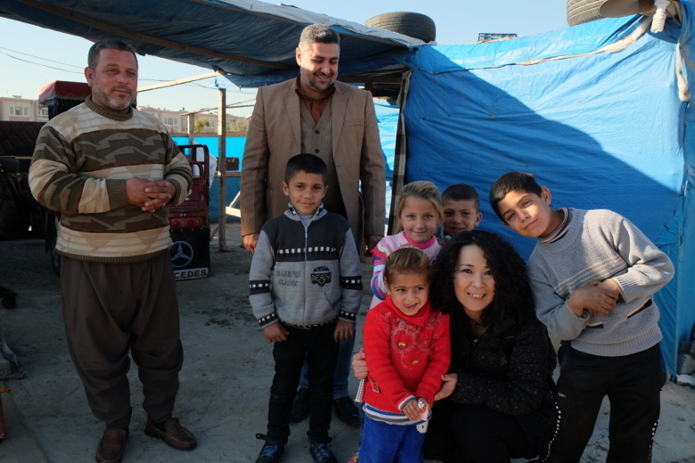 道路脇の小屋に住んでいた避難民一家と高遠さん。国連等の支援を受けられない人々はあまりに多い