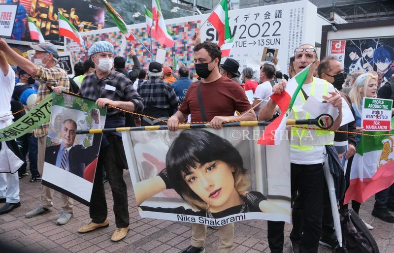 二カ・シャクラミさんの写真を手に抗議する在日イラン人の人々　JR渋谷駅前で筆者撮影