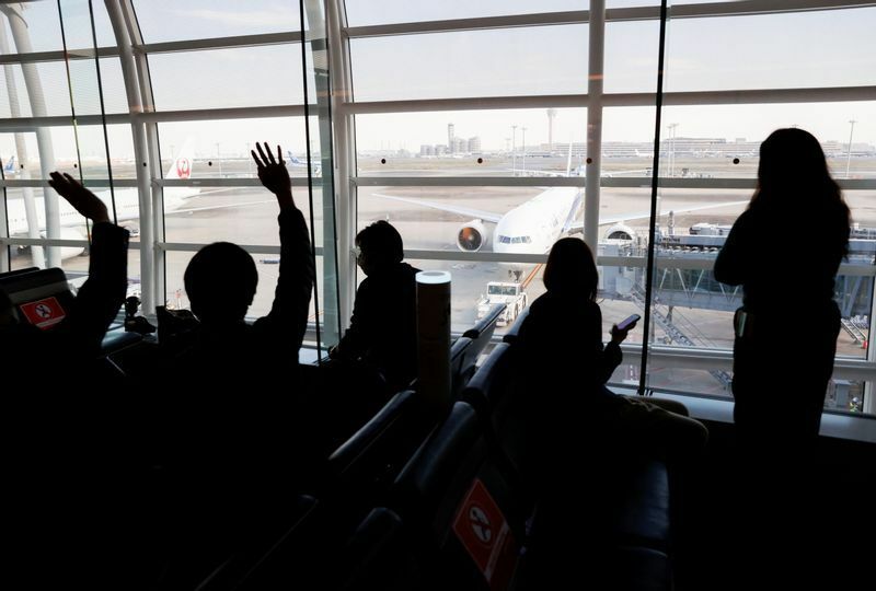 2021年11月14日、東京・羽田空港で、小室夫妻の乗る飛行機に手を振るひとびと。REUTERS/Issei Kato (Japan)