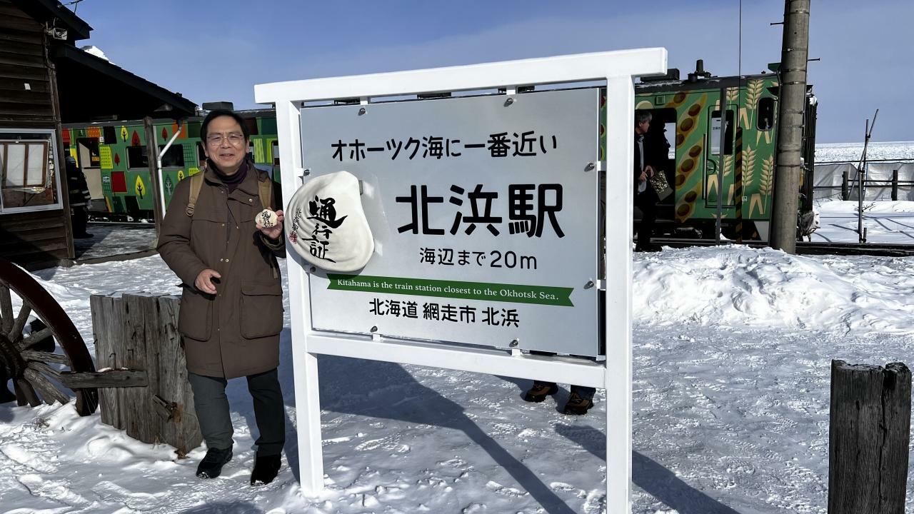 北浜駅に設置された案内板。左側は北海道観光資源創造センター理事の大熊一精さん。ホンモノの貝殻通行証を見せてくれました。手に注目。(筆者撮影)