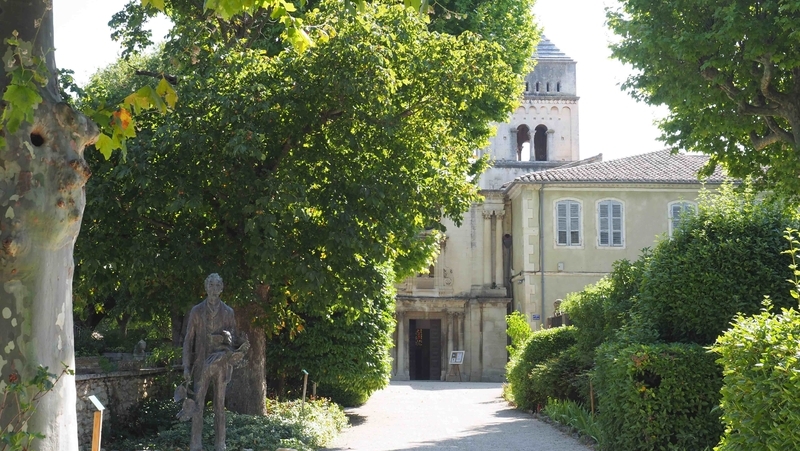 オリーブの林を抜けると、サン・ポール・ド・モゾルの建物が見えてくる。左手の木陰にあるのは、ゴッホの彫像