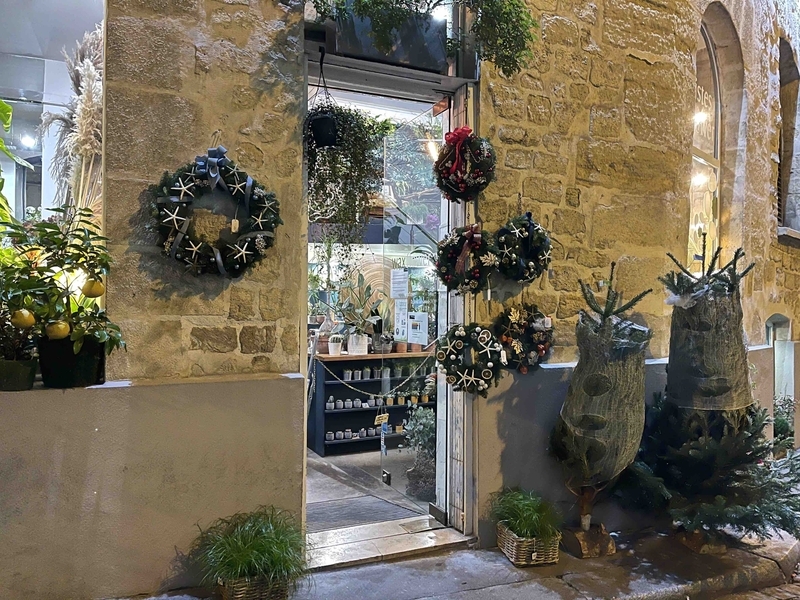 街角の花屋さん。店内での営業はできませんが、クリスマスツリー（白いネットで保護）は販売が認められています