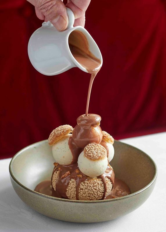 コースメニューのデザートの1品「プロフィトロール」。バニラアイスを詰めたシュー生地に熱々のチョコレートソースをかけていただくフランス料理の定番デザート。シュー生地のテクスチャーなどに名店の技が見える